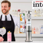 Bartender with a serve standing next to a London Essence-branded font on a bar