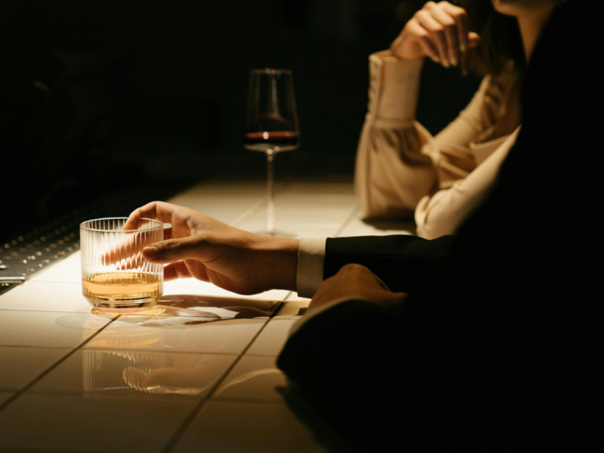 Person in a suit at a bar with an aged spirit in a glass