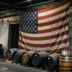 An American flag hanging above four barrels