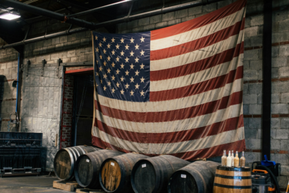 An American flag hanging above four barrels