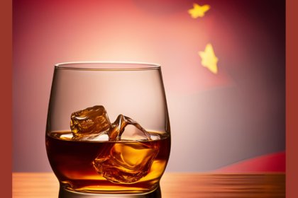 AI-generated image of a glass of brown spirit over ice with a Chinese flag in the background