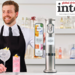 Bartender with a serve standing next to a London Essence-branded font on a bar