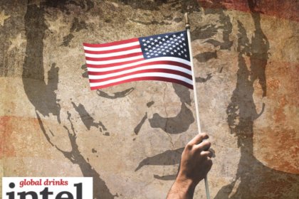 American flag against backdrop of mural of Donald Trump