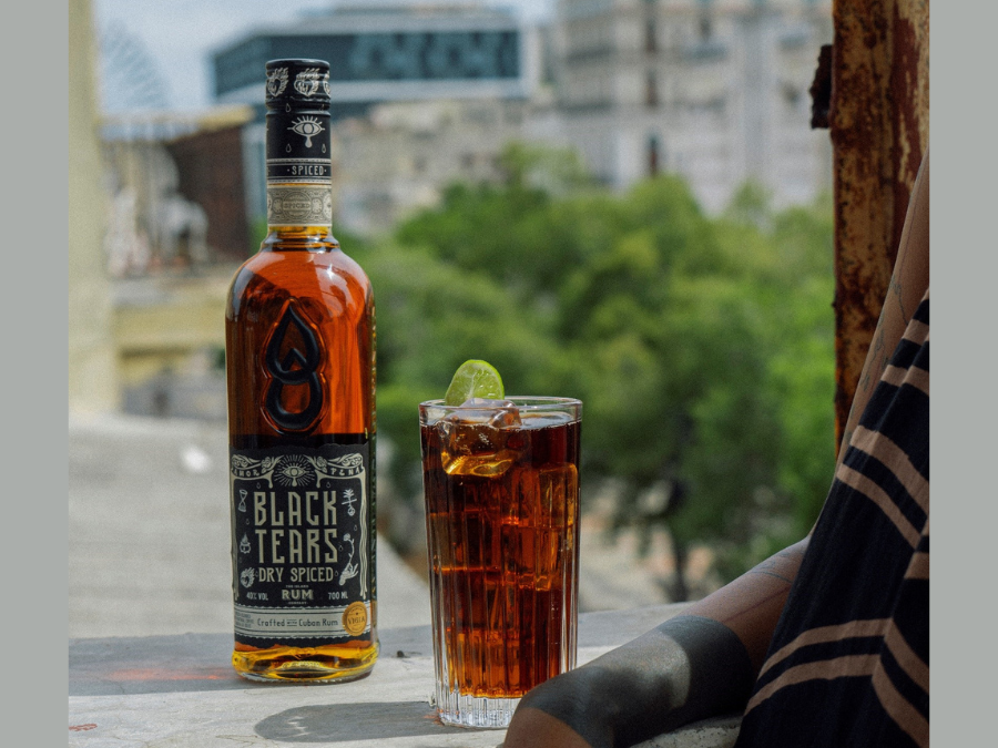 Bottle of Black Tears Spiced Rum with a serve