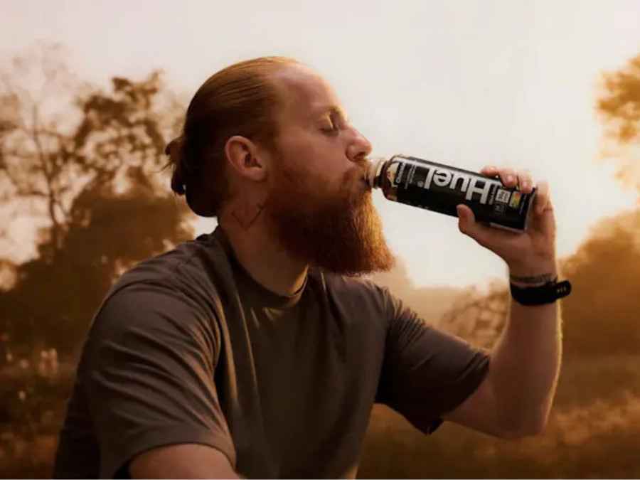 A bearded man consuming a pre-mix variant of Huel