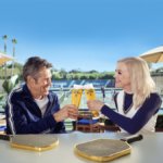 Willem Dafoe and Catherine O'Hara clinking Michelob Ultra beers