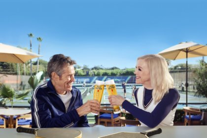 Willem Dafoe and Catherine O'Hara clinking Michelob Ultra beers