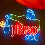 Neon sign with bottle pouring Jinro Soju and writing