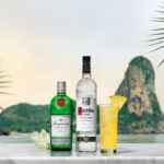 Ketel One and Tanqueray bottles with White Lotus punch cocktail