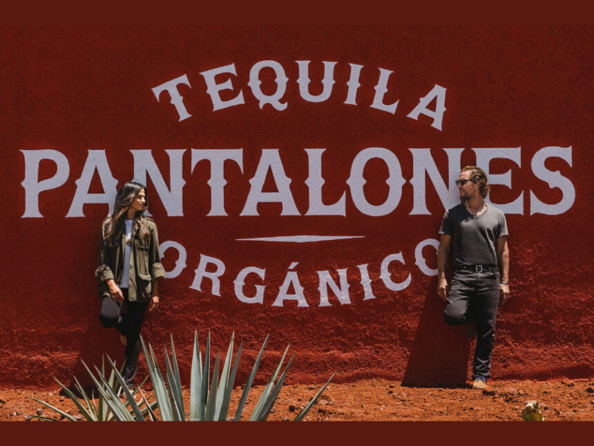 Camila and Matthew McConaughey in front of Pantalones tequila sign