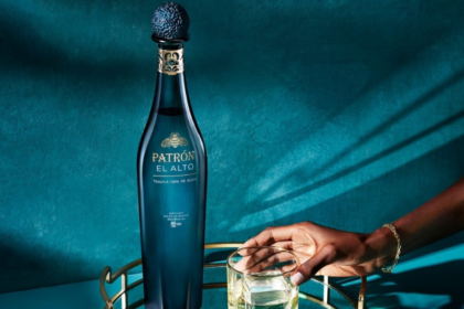 Patron El Alto bottle next to full sipping glass