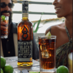 Bottle of Black Tears Dry Spiced Rum with a cuba libre serve