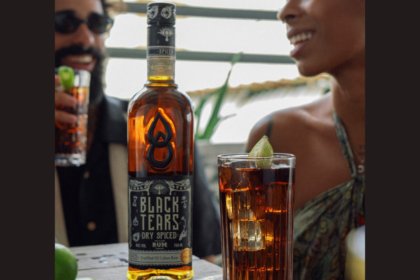 Bottle of Black Tears Dry Spiced Rum with a cuba libre serve
