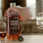 Green River whiskey bottle held by ghost's hand next to serve