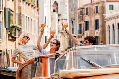 Three people raising glasses on a boat