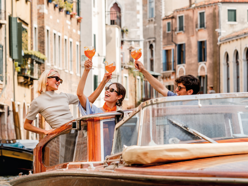 Three people raising glasses on a boat