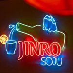 Neon sign with bottle pouring Jinro Soju and writing