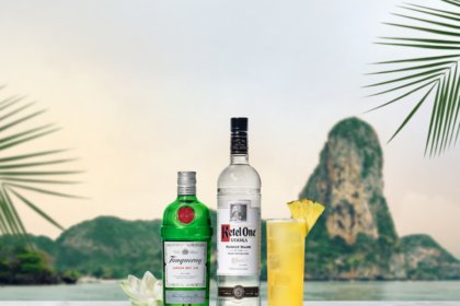 Ketel One and Tanqueray bottles with White Lotus punch cocktail