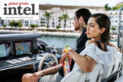 A man and a woman on a boat holding a can of Lyre's non-alcoholic premix cocktail