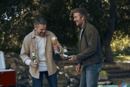 Matt Damon and David Beckham laughing with Stella Artois beer