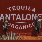 Camila and Matthew McConaughey in front of Pantalones tequila sign
