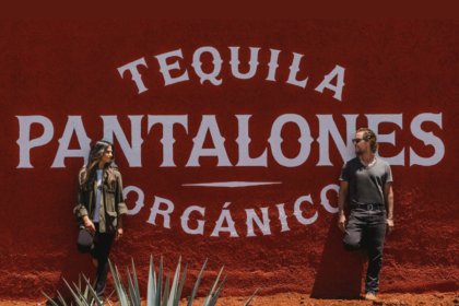 Camila and Matthew McConaughey in front of Pantalones tequila sign