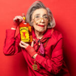 Elderly woman holding bottle of Fireball cinnamon whisky