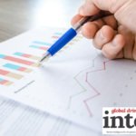 Close-up of charts on a sheet with a pen