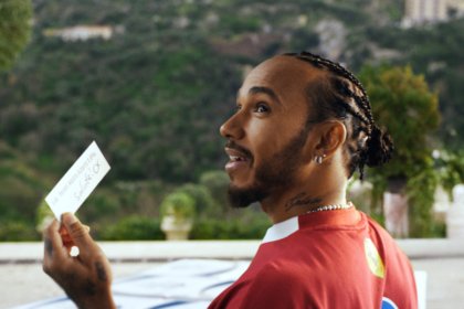 Lewis Hamilton holding Peroni invitation