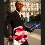 Pharrell Williams holding Moet & Chandon bottle and bunch of flowers
