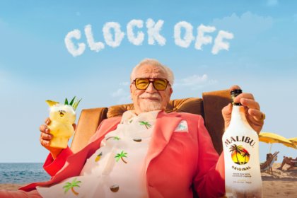 Brian Cox holding a Malibu bottle and serve with 'Clock Off' in the background
