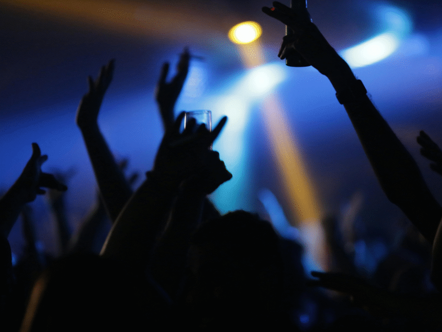 Nightclub interior dancers holdings drinks in the air