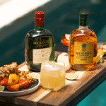 Buchanan's whisky bottles next to serves and grilled food