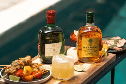 Buchanan's whisky bottles next to serves and grilled food
