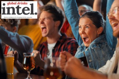 People at a bar cheering a sporting event on TV