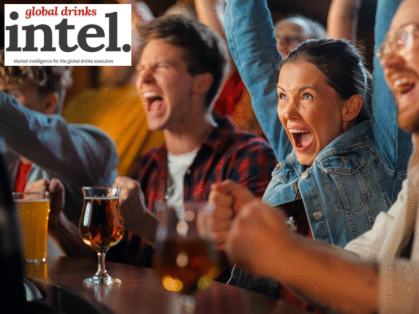 People at a bar cheering a sporting event on TV