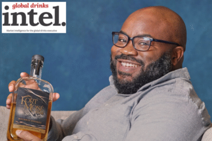 Charles Everett holding a bottle of Fort Mosé 1738 Black-owned American whiskey