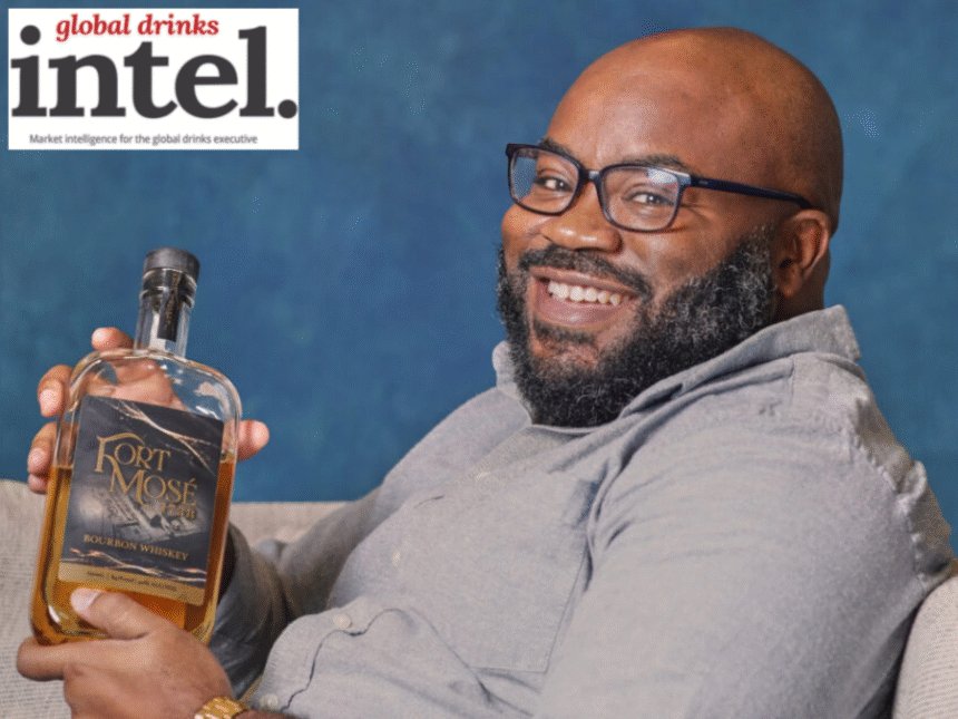 Charles Everett holding a bottle of Fort Mosé 1738 Black-owned American whiskey