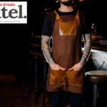 Bartender standing in front of a bar