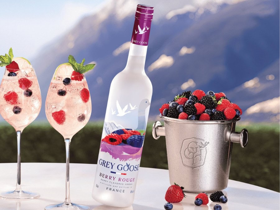 Bottle of Grey Goose Berry Rouge on a table next to ice cooler and glasses