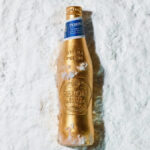 A limited-edition gold bottle for Peroni Nastro Azzurro lying in the snow