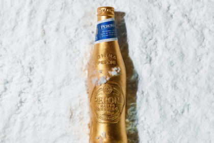 A limited-edition gold bottle for Peroni Nastro Azzurro lying in the snow