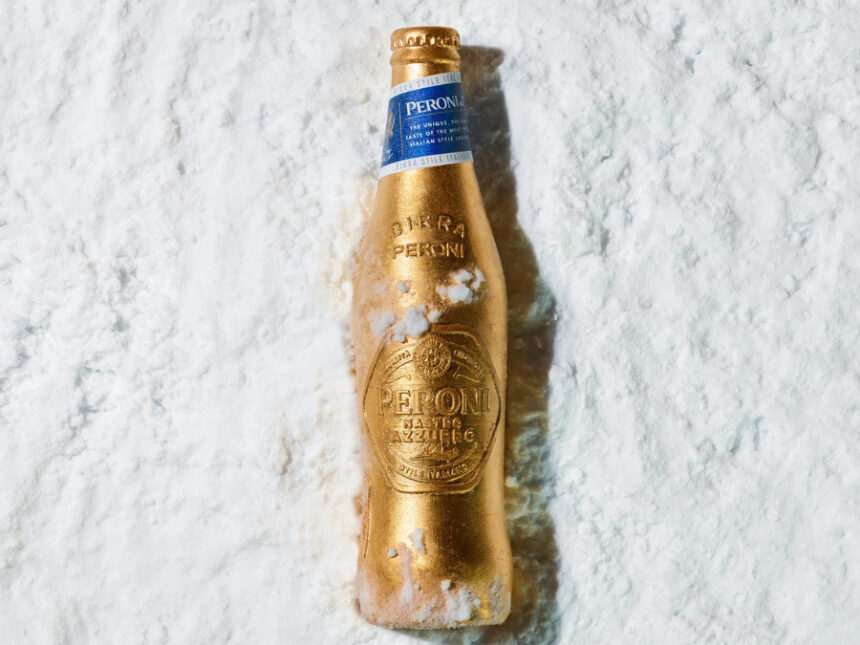 A limited-edition gold bottle for Peroni Nastro Azzurro lying in the snow