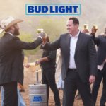 Two white men cheers a Bud Light beer at a wedding