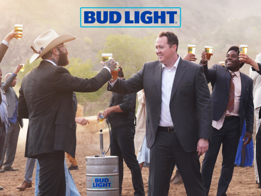 Two white men cheers a Bud Light beer at a wedding