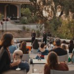 A singer performs at a winery in an ampitheatre-shaped space with people drinking wine