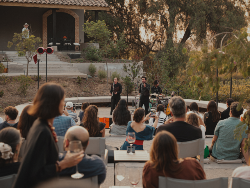 A singer performs at a winery in an ampitheatre-shaped space with people drinking wine