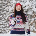 Olympic gold medalist Chloe Kim stands in a snowy scene holding a beer