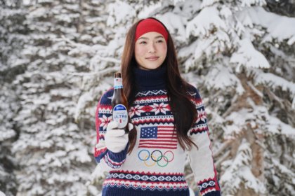Olympic gold medalist Chloe Kim stands in a snowy scene holding a beer