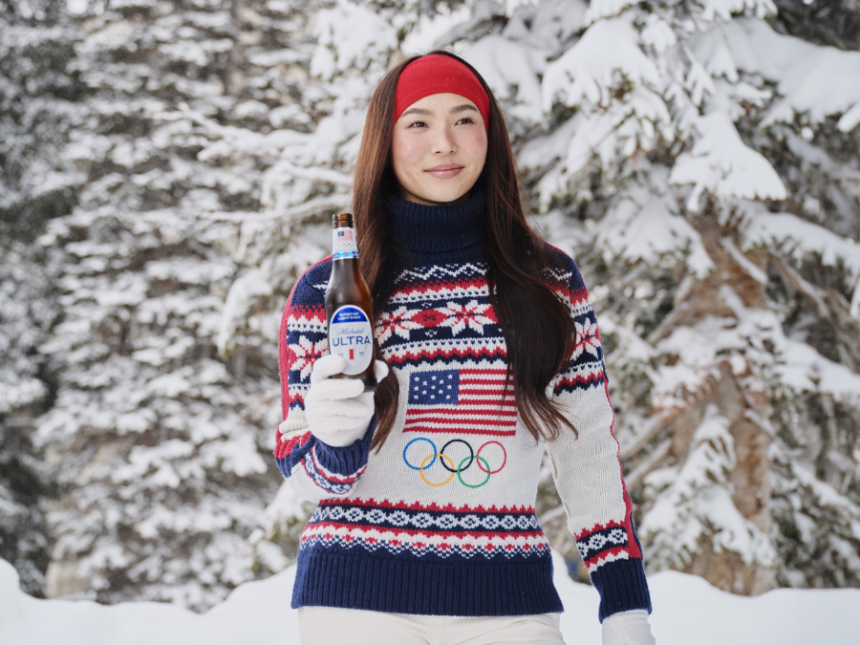 Olympic gold medalist Chloe Kim stands in a snowy scene holding a beer